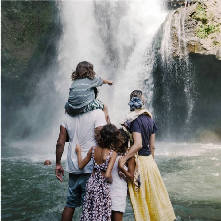 A young family takes in the grandeur of a massive waterfall.