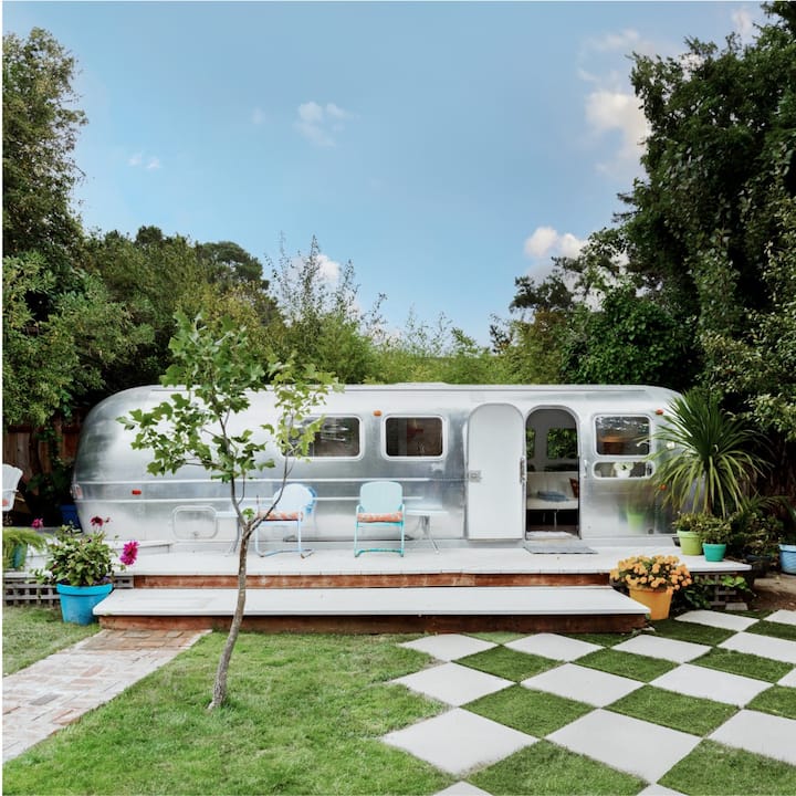 An airstream trailer in front of a checkerboard lawn.