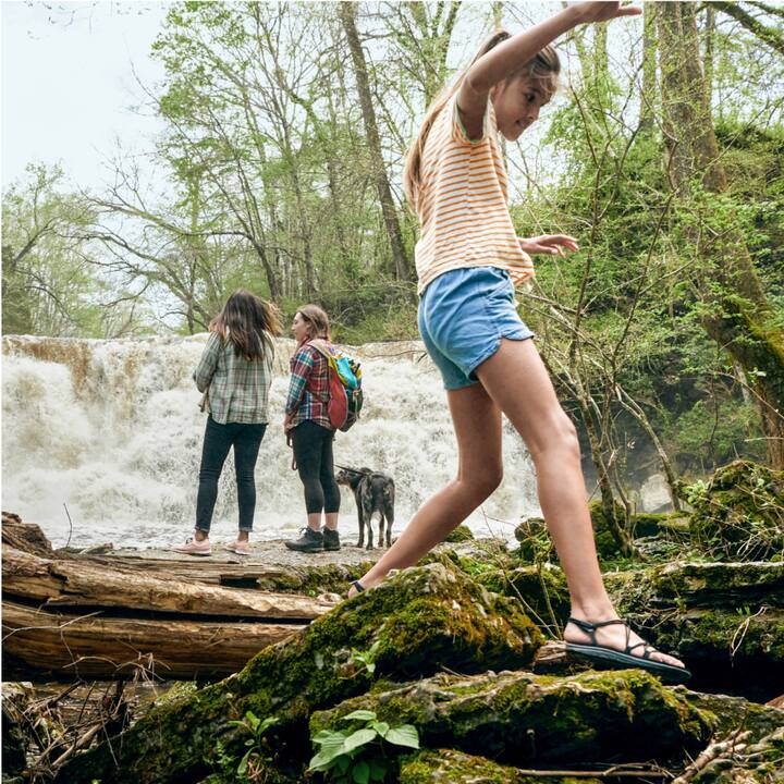 A group of children play near a miniature waterfall.