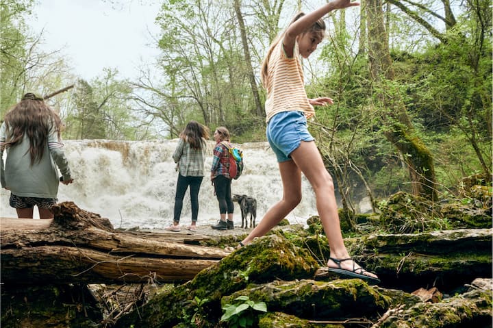 A group of children play near a miniature waterfall.