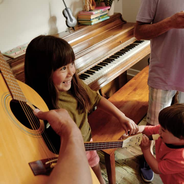 Two smiling kids dance and take part in a music class.