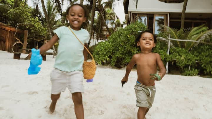 Two cute toddlers happily head to the beach. 