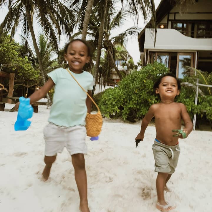 Two cute toddlers happily head to the beach. 