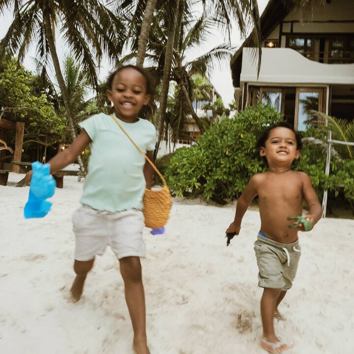 Two cute toddlers happily head to the beach. 