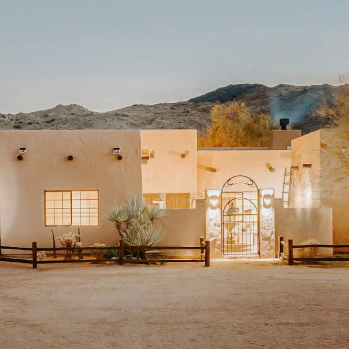 A beautiful desert home all lit up at dusk.