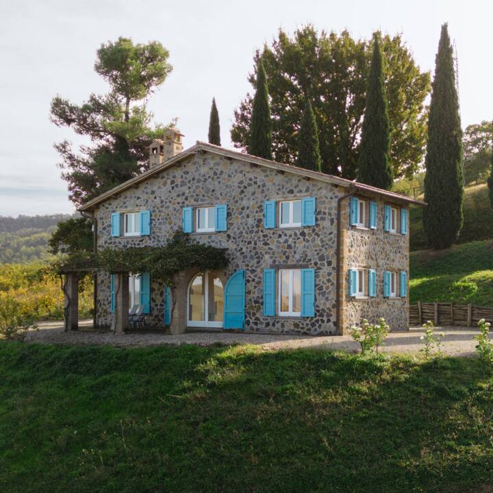 A picturesque view of an old and charming brick house with sky blue shutters.