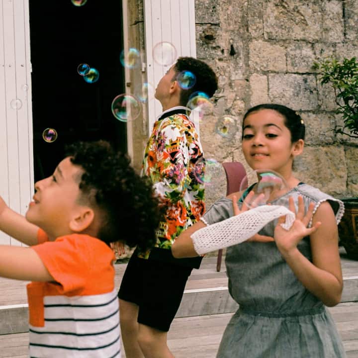 A family blows bubbles together in the courtyard. 
