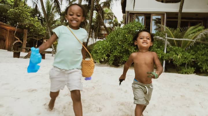 Two cute toddlers happily head to the beach.