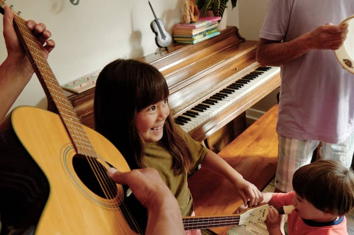 Two smiling kids dance and take part in a music class. 