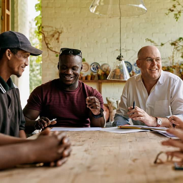 Hosts around a table for Host Clubs landing page