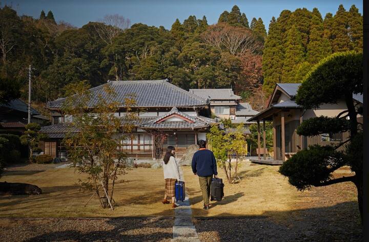 Two guests arrive for a stay at a beautiful home by a forest