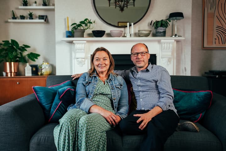 Alex & Lisa sitting on their sofa