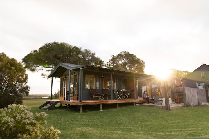 Couple standing outside their queensland home with kayaks resting on wall
