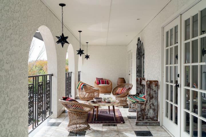 A balcony with hanging lights in the shape of stars and wicker furniture
