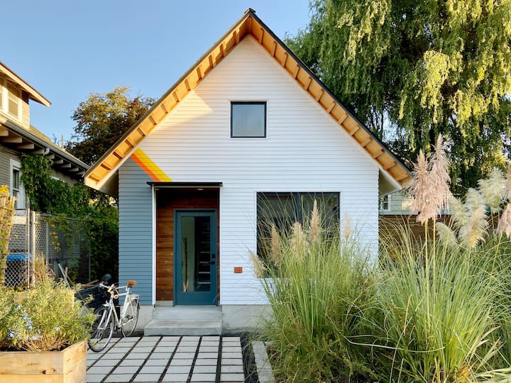 Front-facing photo of a tiny, white A-frame home