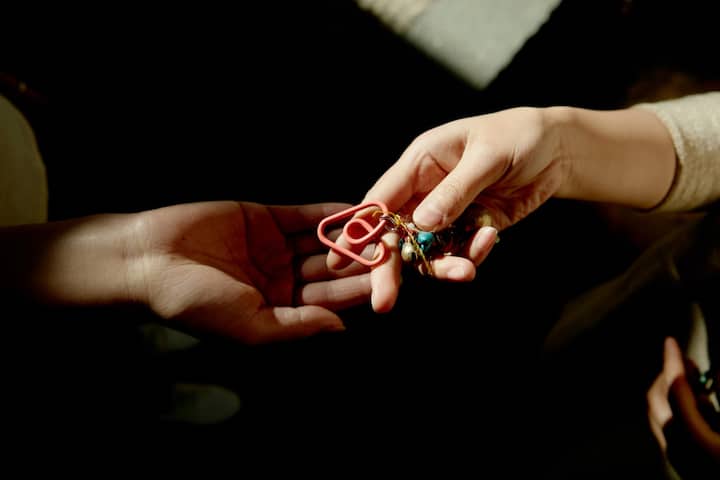 Close-up of two hands exchanging house keys, symbolizing a call to action.