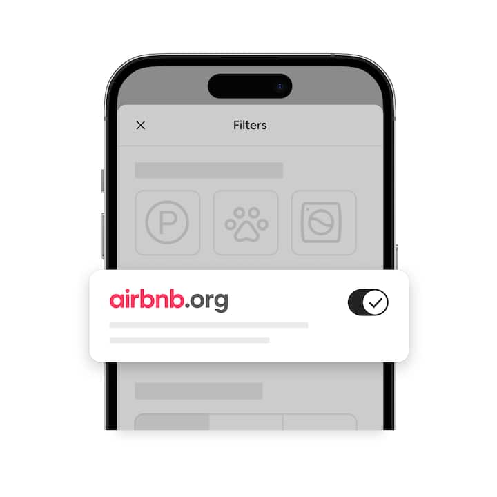 Phone with a muted image of Airbnb’s search screen and a bright, enlarged image of Airbnb.org’s logo next to a toggle button.