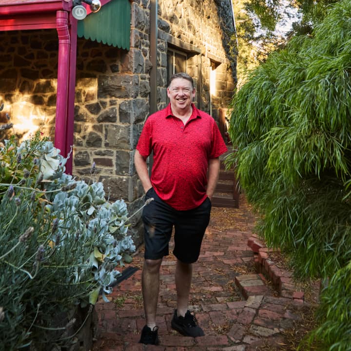 Geoff Gedge outside on a brick path next to his listing 