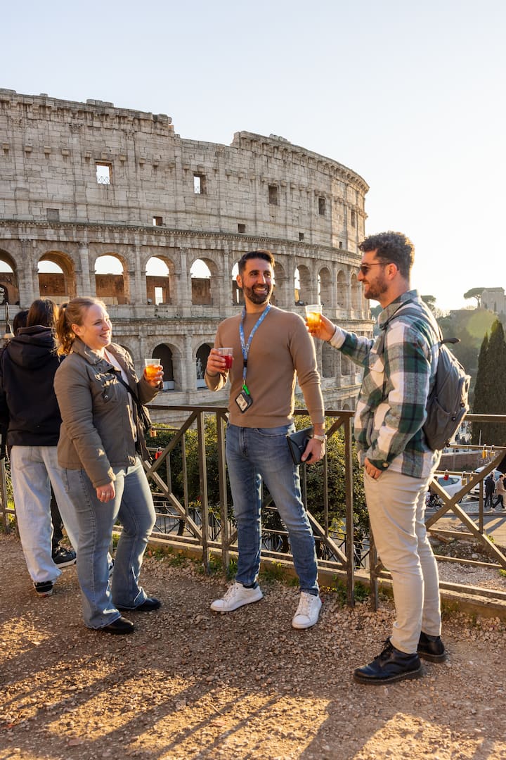 Three people enjoying drinks in front of the Colosseum in Rome.