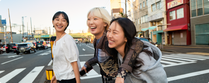 Three women are enjoying a walk through the city of Osaka, which they visited on their Airbnb trip.