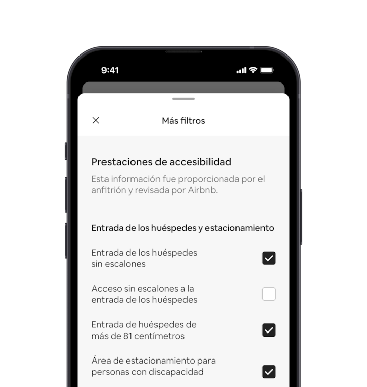 Un celular muestra la función de más filtros, que es uno de los muchos filtros de búsqueda. Hay un encabezado de sección que dice “Prestaciones de accesibilidad”. Debajo de las prestaciones de accesibilidad están agrupadas por zonas como “Entrada de los huéspedes y estacionamiento”. Hay casillas de verificación donde puedes seleccionar todas las prestaciones que quieras.