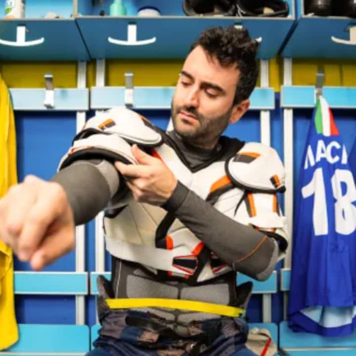 Sports gear being adjusted in a locker room, featuring a blue jersey with the number 18 and an Italian flag on display.