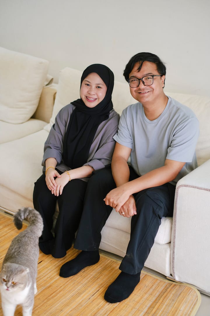 Den malaysiska värden Amirul sitter i soffan med sin fru Izzati
