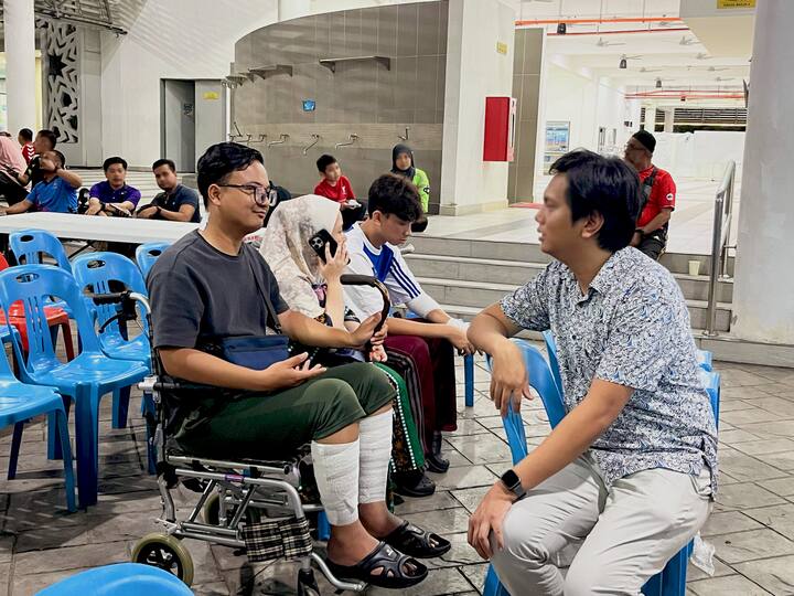 Amirul, a host in a wheelchair, talking to Matin from Airbnb.