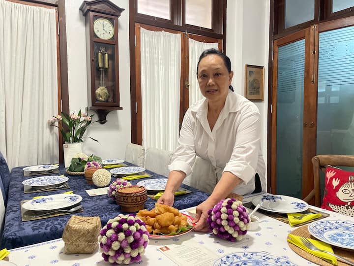 Pariya, a superhost in Thailand, is setting up her dining table as she prepares to host guests.