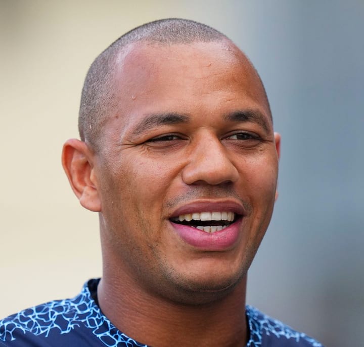 Close-up of Gael Fickou wearing a dark blue shirt with a geometric pattern, promoting his T1 Airbnb experience.