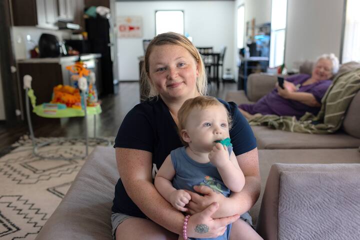 Airbnb.org-gjesten Skylyn og hennes ti måneder gamle sønn Wayon sitter i Airbnb-hjemmet de bor i.