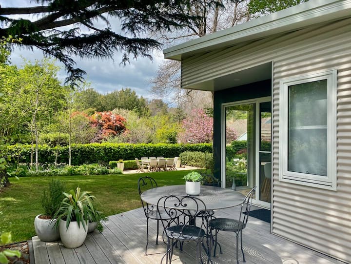 Patio with outdoor dining set overlooking a lush garden.