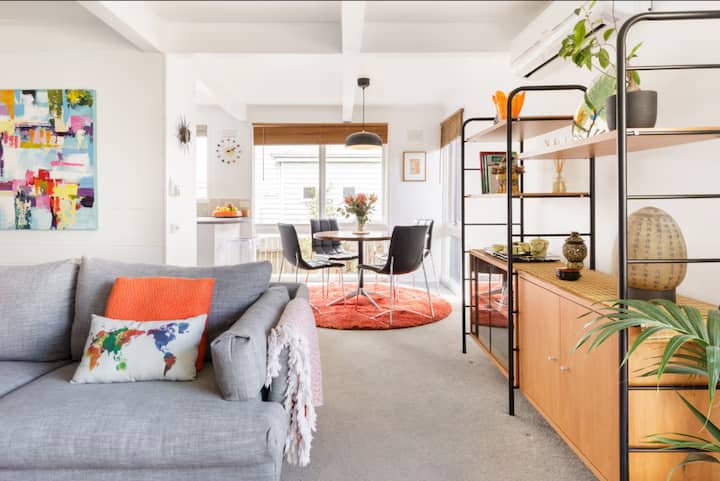 Bright living and dining room with colorful decor and modern furnishings.