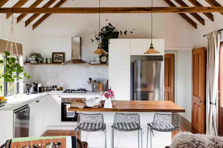 Cozy kitchen with wooden beams, white cabinets, and a central island.