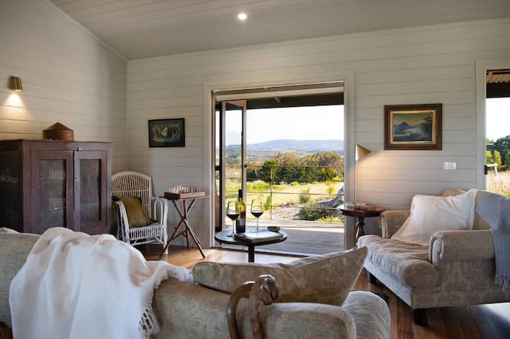 Cozy living room with vintage furniture and a view of the countryside.