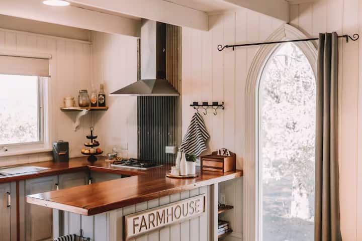Farmhouse-style kitchen with wooden counters and rustic decor.