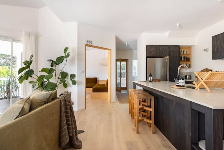 Open-plan interior with a modern kitchen featuring dark cabinetry,