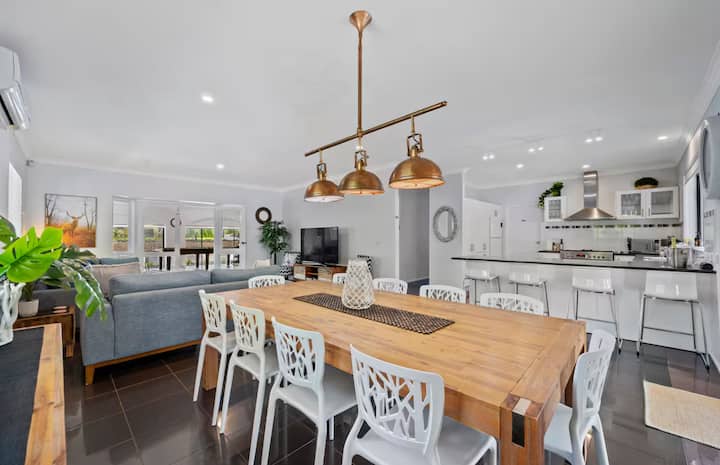 Open-plan dining and kitchen with wooden table.