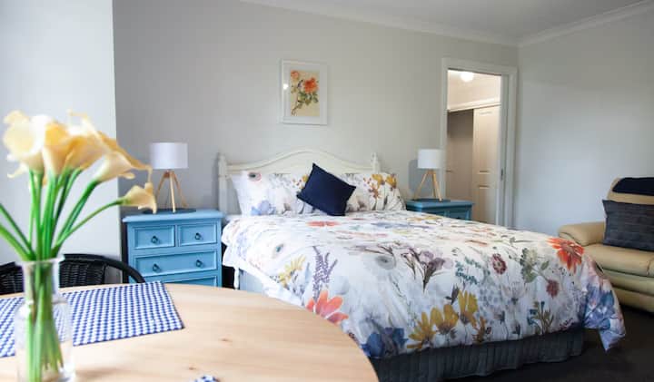 Bedroom with floral bedding and blue nightstands