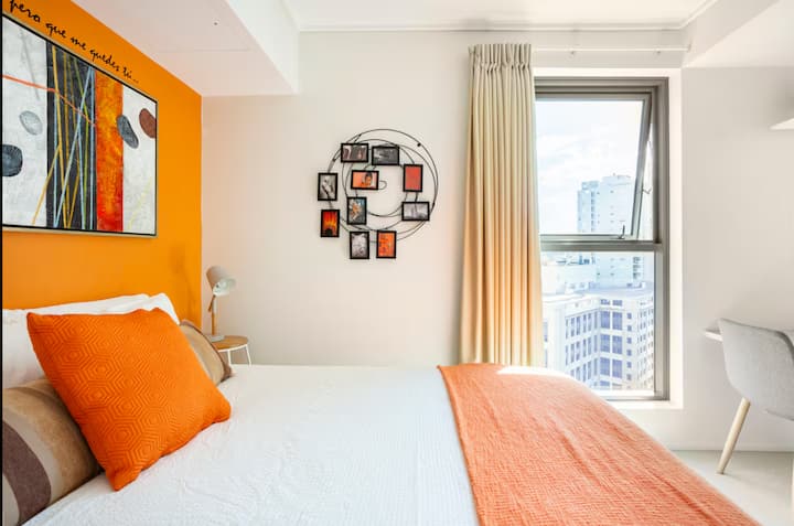 Bedroom with orange accent wall and decor