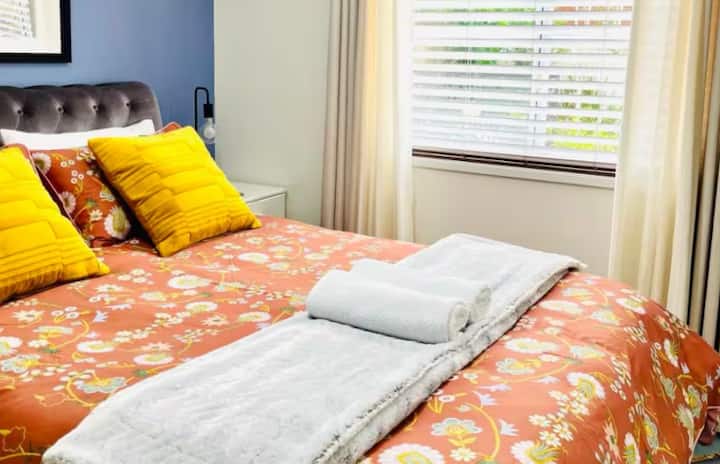 Bright bedroom with floral bedding and mustard pillows