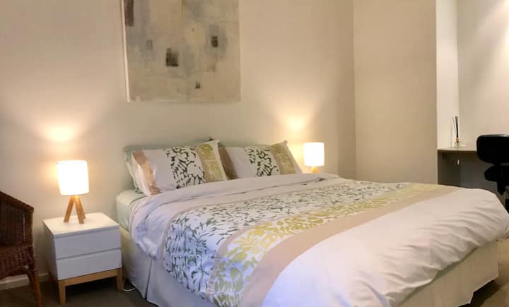 Minimalist bedroom with soft lighting and abstract art