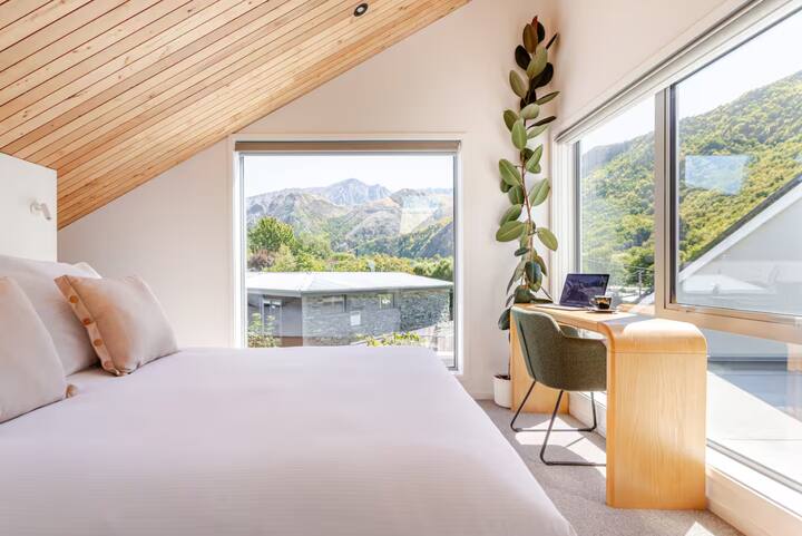 Sunlit loft bedroom with mountain views and cozy workspace