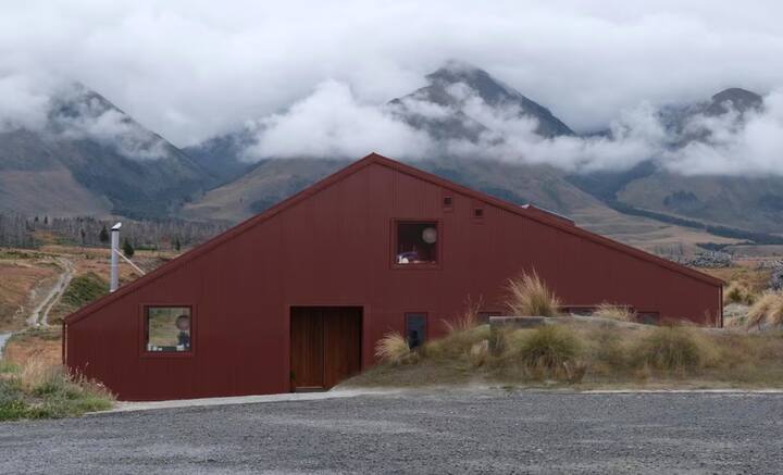 Modern barn-style home against misty mountain backdrop
