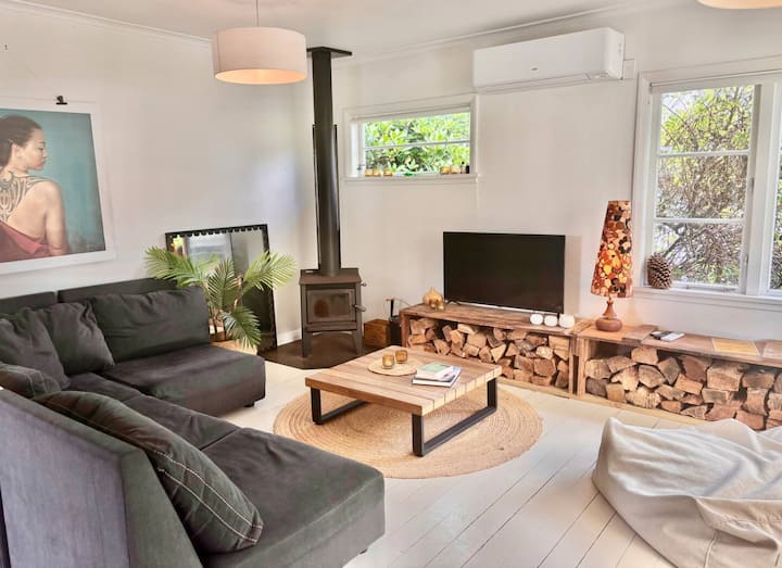 Cozy lounge with wood burner and rustic log storage