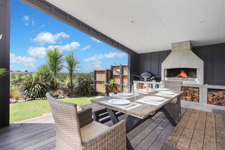 Outdoor dining area with fireplace and countryside views