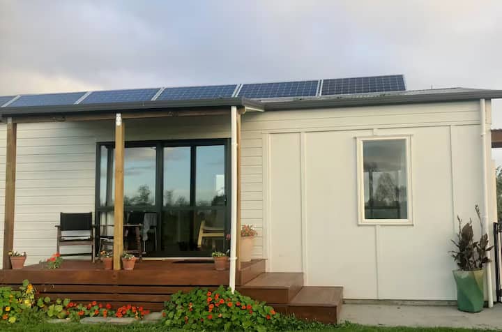 Tiny home with solar panels and front deck