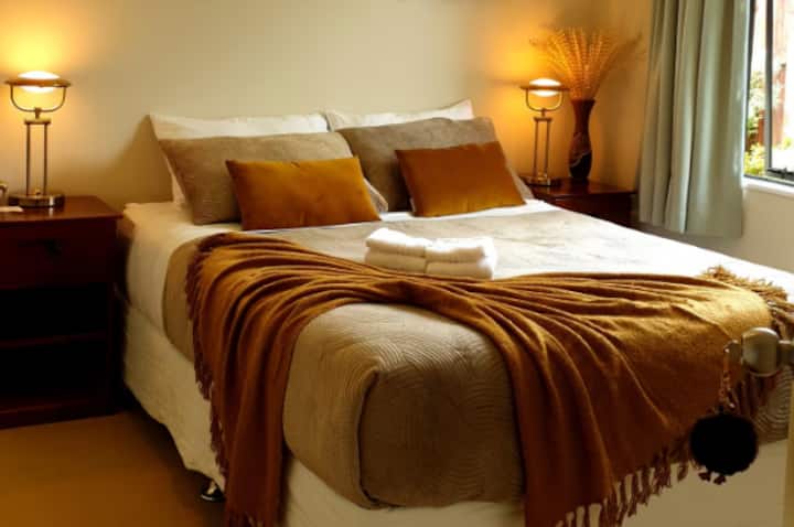 Cozy bedroom with golden throw and pillows