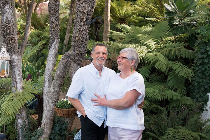 Smiling elderly couple in lush garden setting