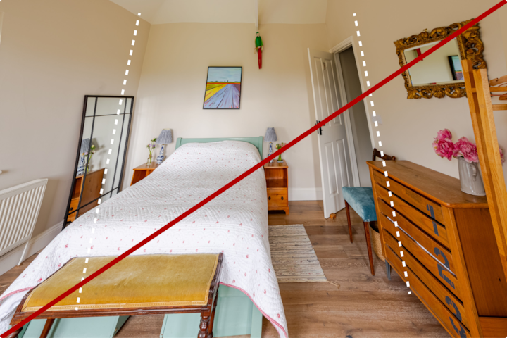 Image déformée d'une chambre à coucher due à l'inclinaison de l'appareil photo vers le plafond, ce qui étire les lignes verticales vers l'extérieur.